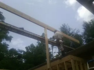 Carpenter setting a ridge beam over a new addition frame — Ice Dam Removal by Roofing Brothers in Murrayville